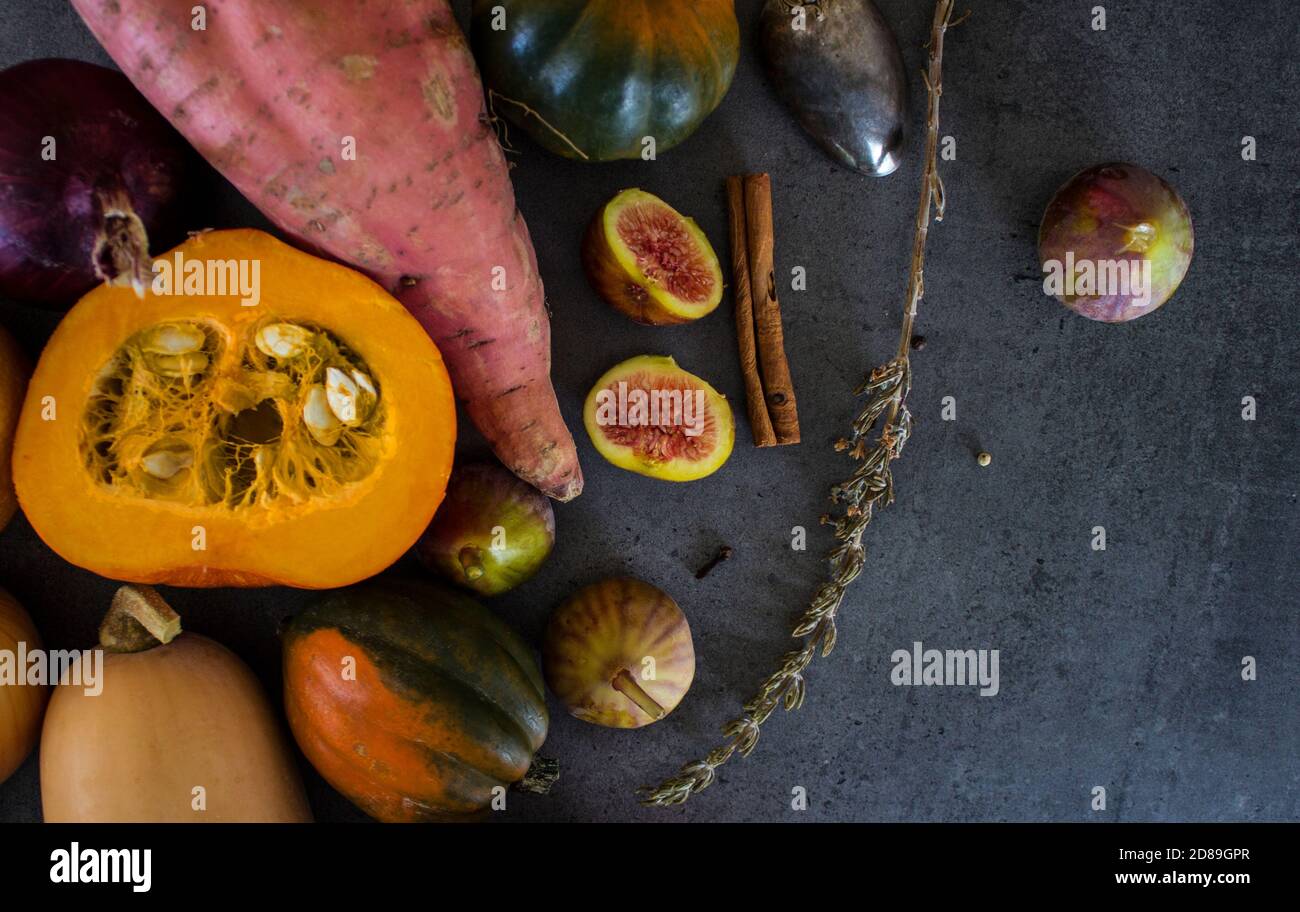 Légumes frais sur fond gris avec espace de copie. Vue de dessus photo de noyer cendré, courge de pierres précieuses, carotte de citrouille dorée, figues, patate douce, oignon. Banque D'Images