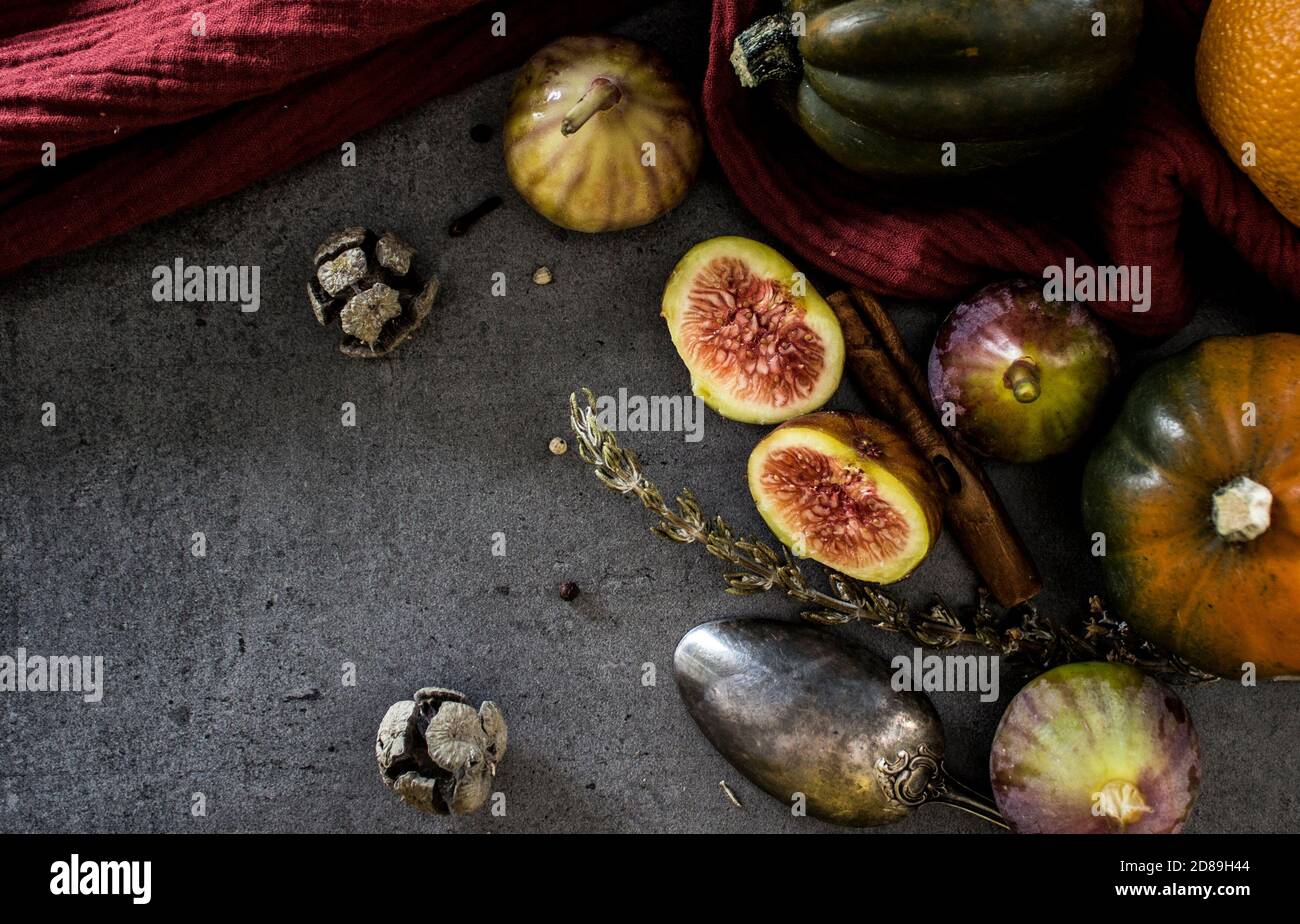 Fruits et légumes frais sur une table. Courge, prunes, figues et cuillère argentée sur fond gris. Photo vue du dessus de la récolte d'automne. Banque D'Images