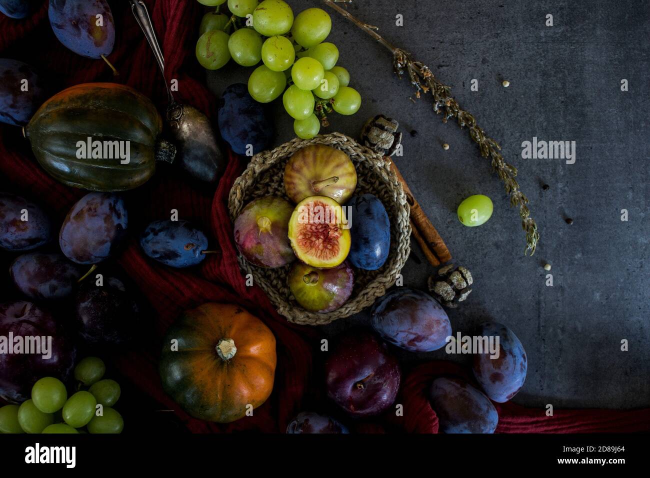 Fruits et légumes frais sur une table. Vue de dessus photo de raisins, citrouilles, prunes et figues. Arrière-plan texturé gris. L'automne encore la vie. Banque D'Images