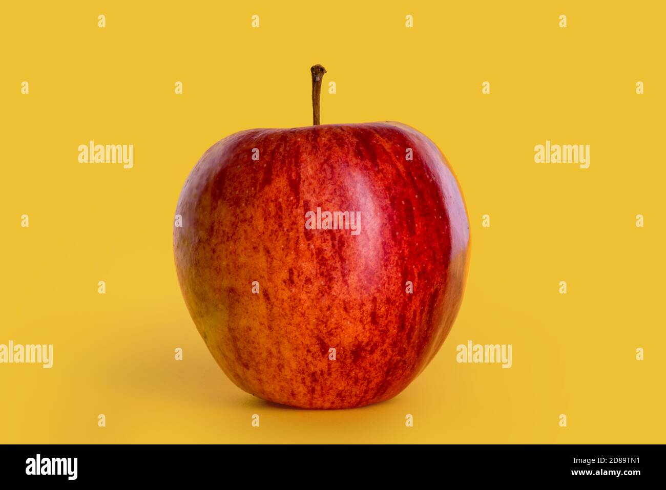 Pomme isolée sur fond jaune, fruit rouge d'automne de la variété appelée fuji Banque D'Images