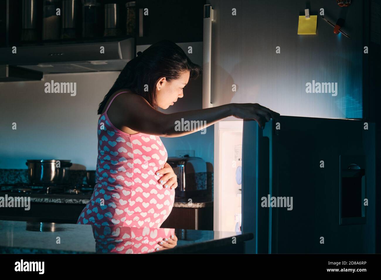 Femme enceinte d'Amérique latine manger la nuit Banque D'Images