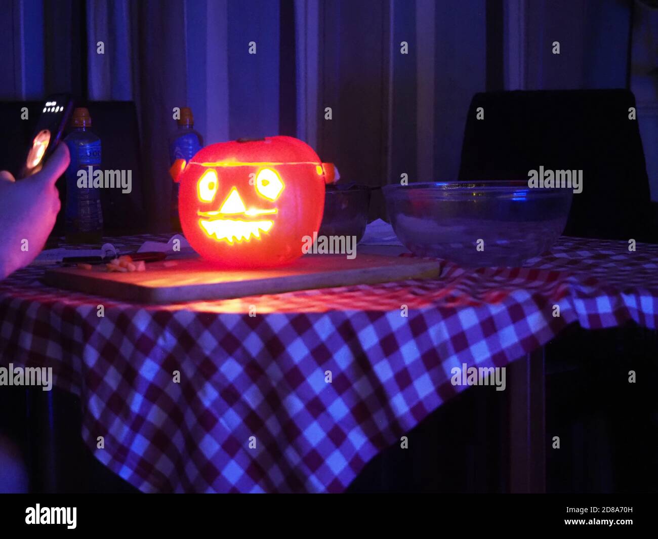 personne prenant la photo du téléphone portable de la citrouille d'halloween sculptée illuminée Banque D'Images