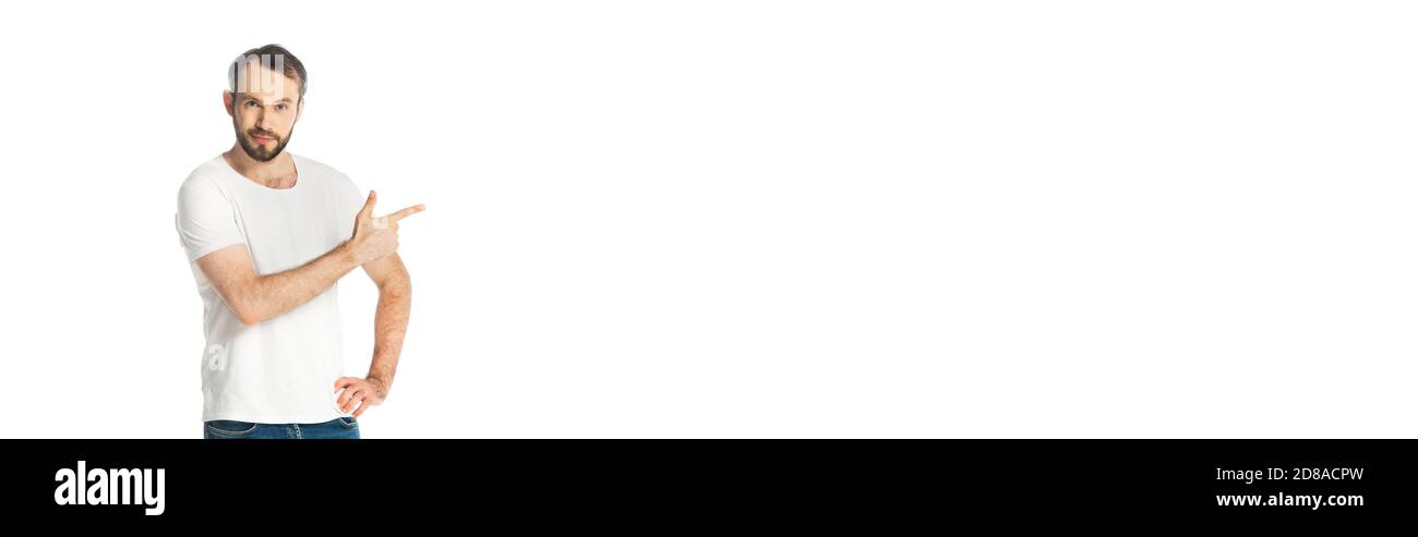 vue avant de l'homme souriant avec la main sur la hanche pointant avec le doigt de côté isolé sur blanc, vue panoramique Banque D'Images