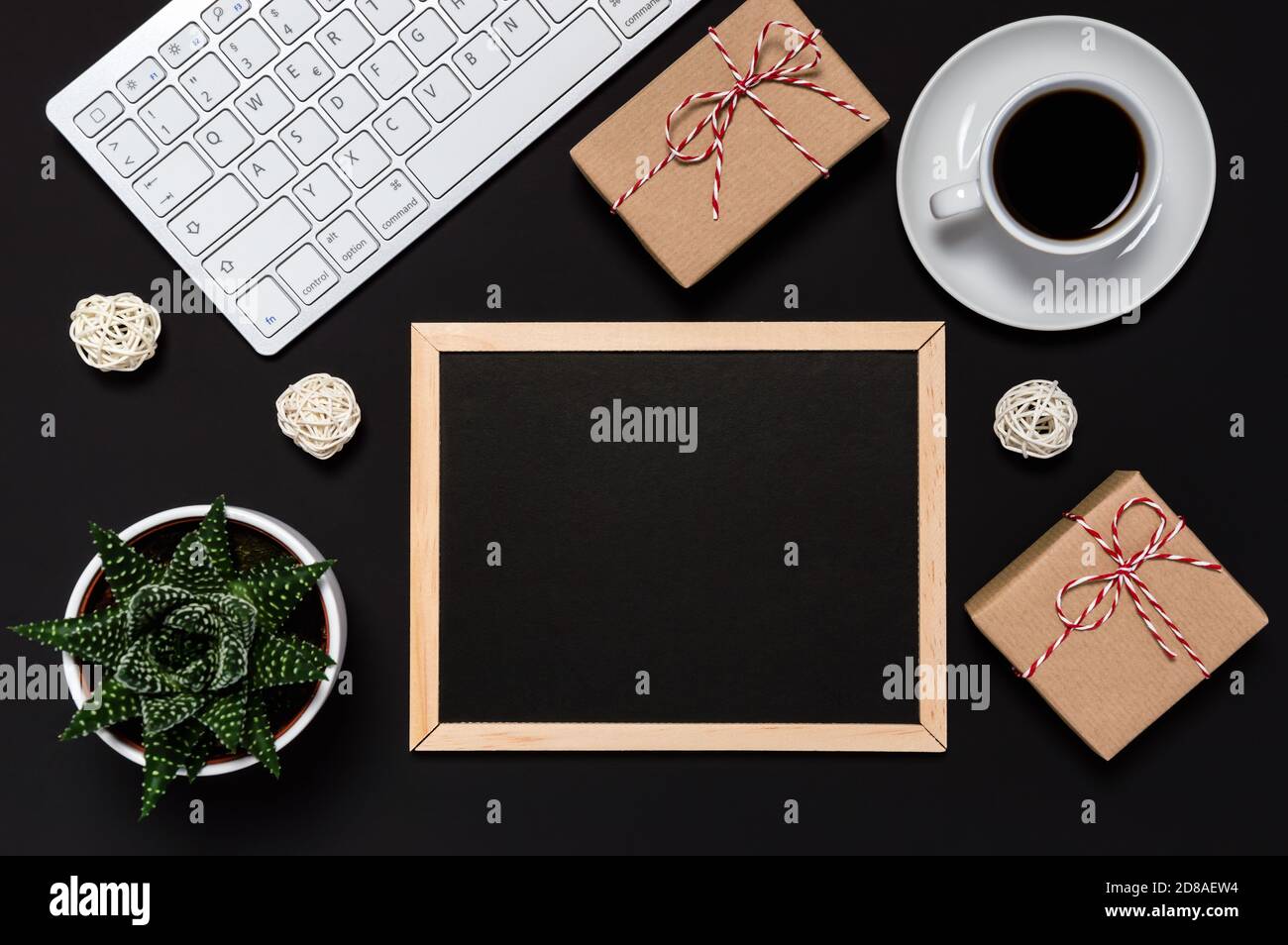 Vente du Vendredi fou et concept d'achat en ligne. Cadeaux, café, clavier et tableau noir avec espace de copie pour votre message sur fond sombre. Vacances Banque D'Images