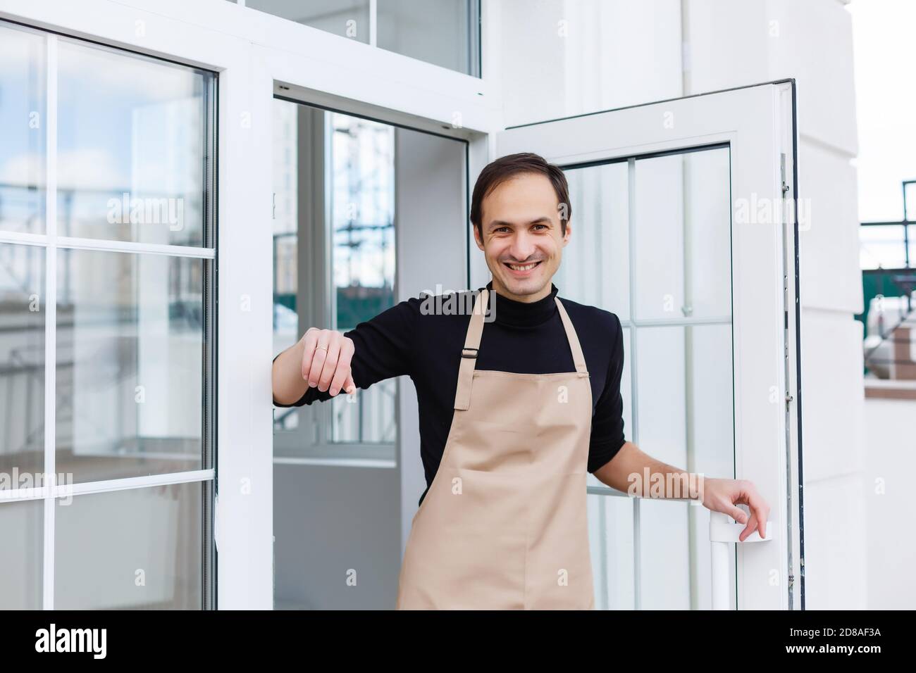 Portrait d'un serveur montrant un panneau ouvert au café boutique Banque D'Images