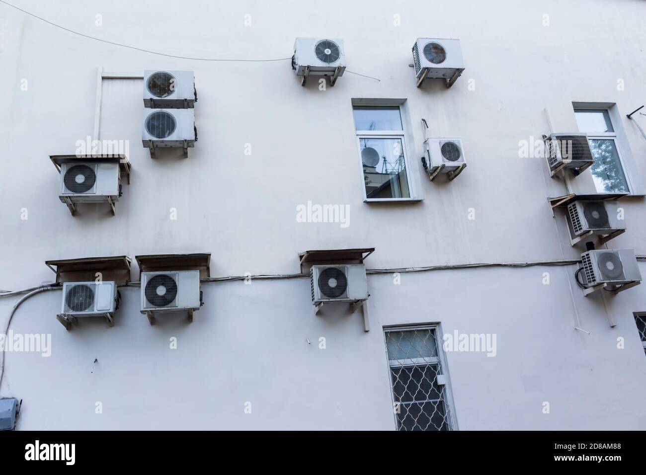Climatiseurs sur le mur de la maison où sont situés les bureaux. Plâtre blanc et boîtiers des unités externes du système de ventilation. Banque D'Images