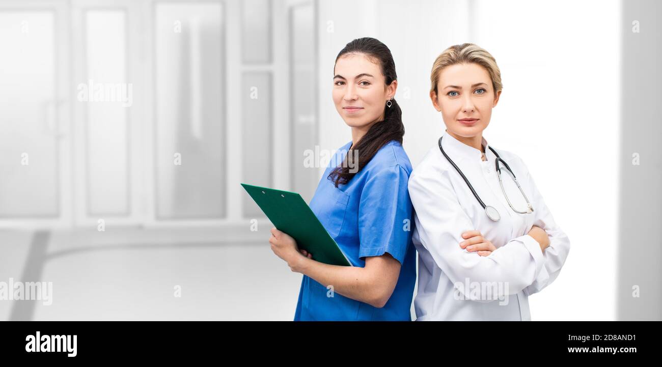 Médecin et infirmière regardant la caméra ensemble à l'hôpital. équipe médicale debout au-dessus d'une clinique de couloir Banque D'Images