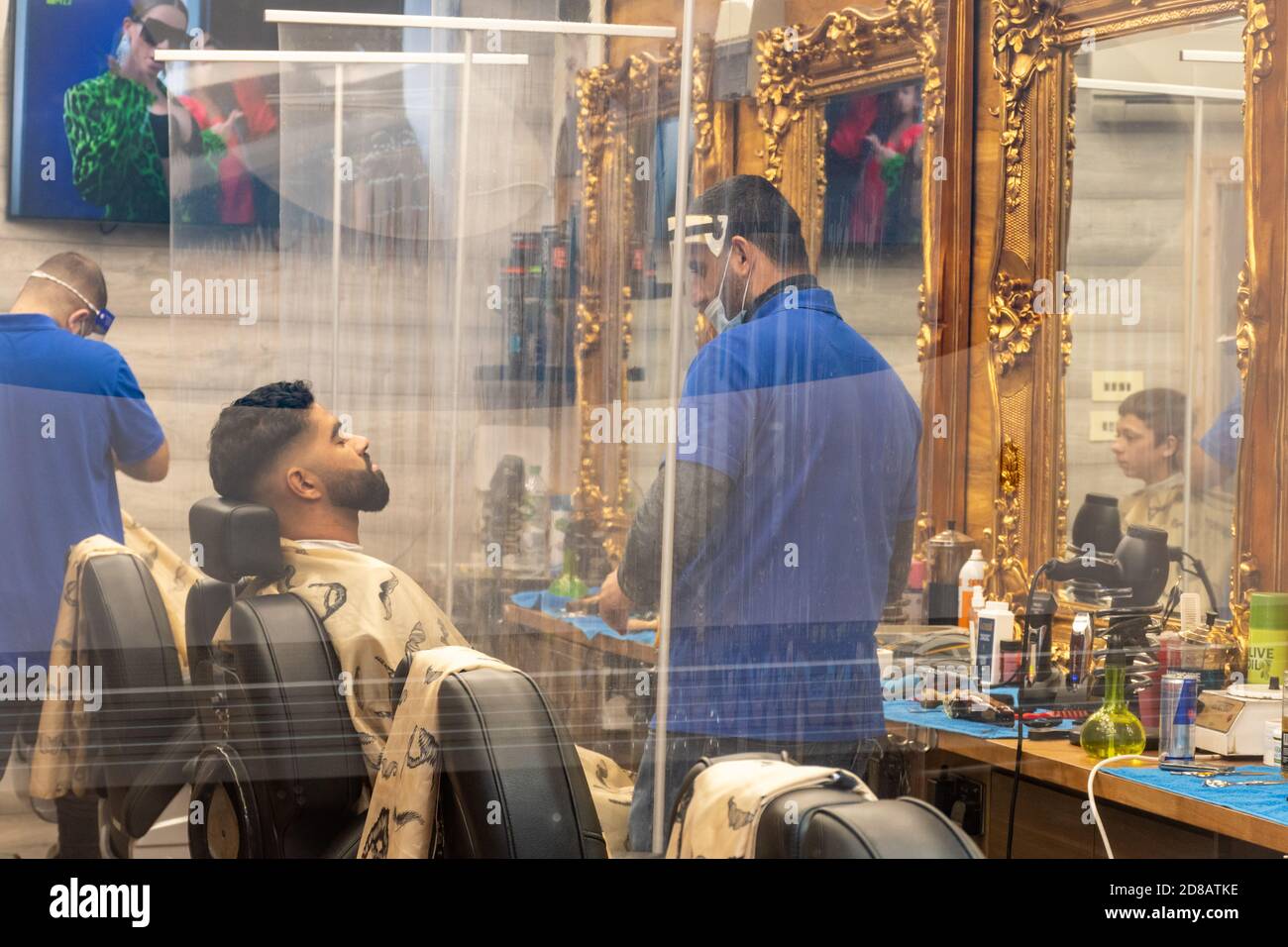 Barbiers travaillant avec des précautions d'affaires de sécurité de covid portant des écrans faciaux pendant la pandémie de coronavirus 2020 de covid-19, Royaume-Uni. La nouvelle norme. Banque D'Images