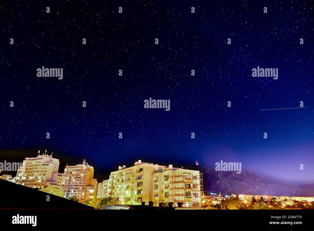 Étoile en chute ou avion visible dans une étoile nuit sur un immeuble de la ville Banque D'Images