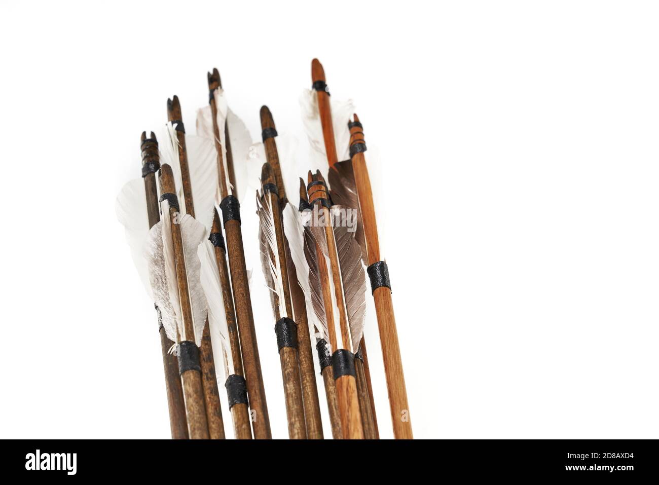 Vue rapprochée des flèches en bois anciennes avec des plumes grises isolées sur fond blanc. Ancienne arme médiévale qualitative. Banque D'Images