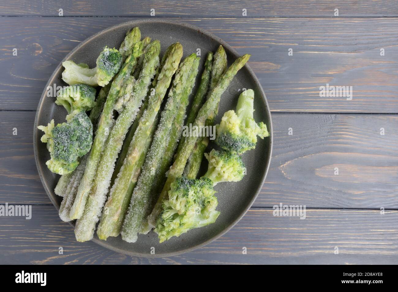 Asperges et brocolis congelés dans une assiette sur une surface en bois  avec un espace pour le texte. Article, recette Photo Stock - Alamy