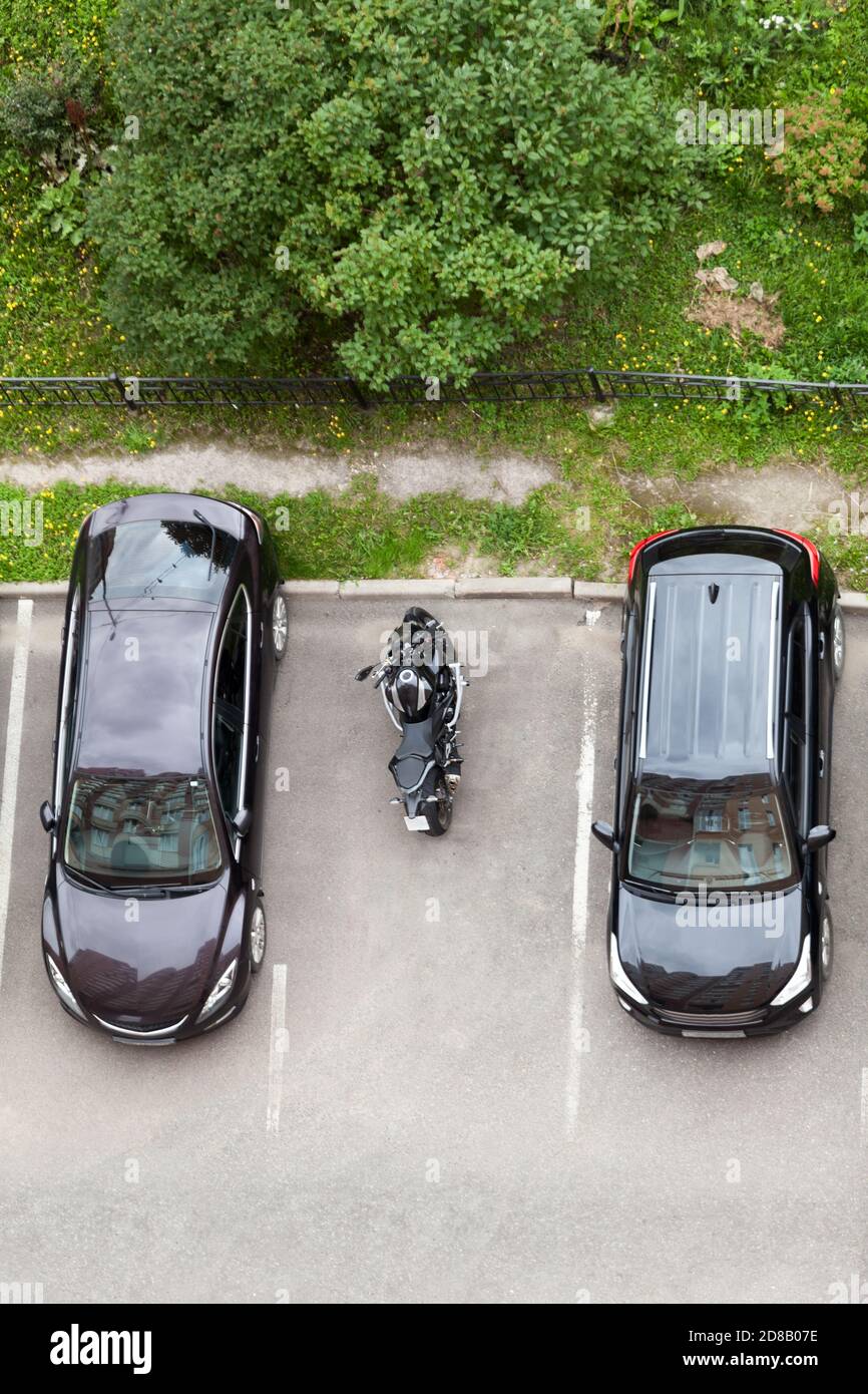 La moto est garée sur une place de stationnement entre deux voitures de  tourisme. Vue de dessus Photo Stock - Alamy