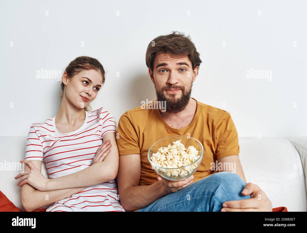 Homme et femme sur le canapé avec pop-corn regardant la télévision affiche  Photo Stock - Alamy