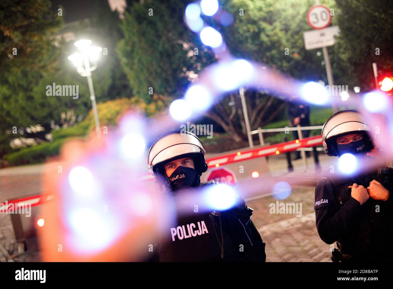 Une femme tient un cintre allumé électroniquement, un symbole des femmes souffrant d'avortements illégaux devant la police anti-émeute à une manifestation ne Banque D'Images