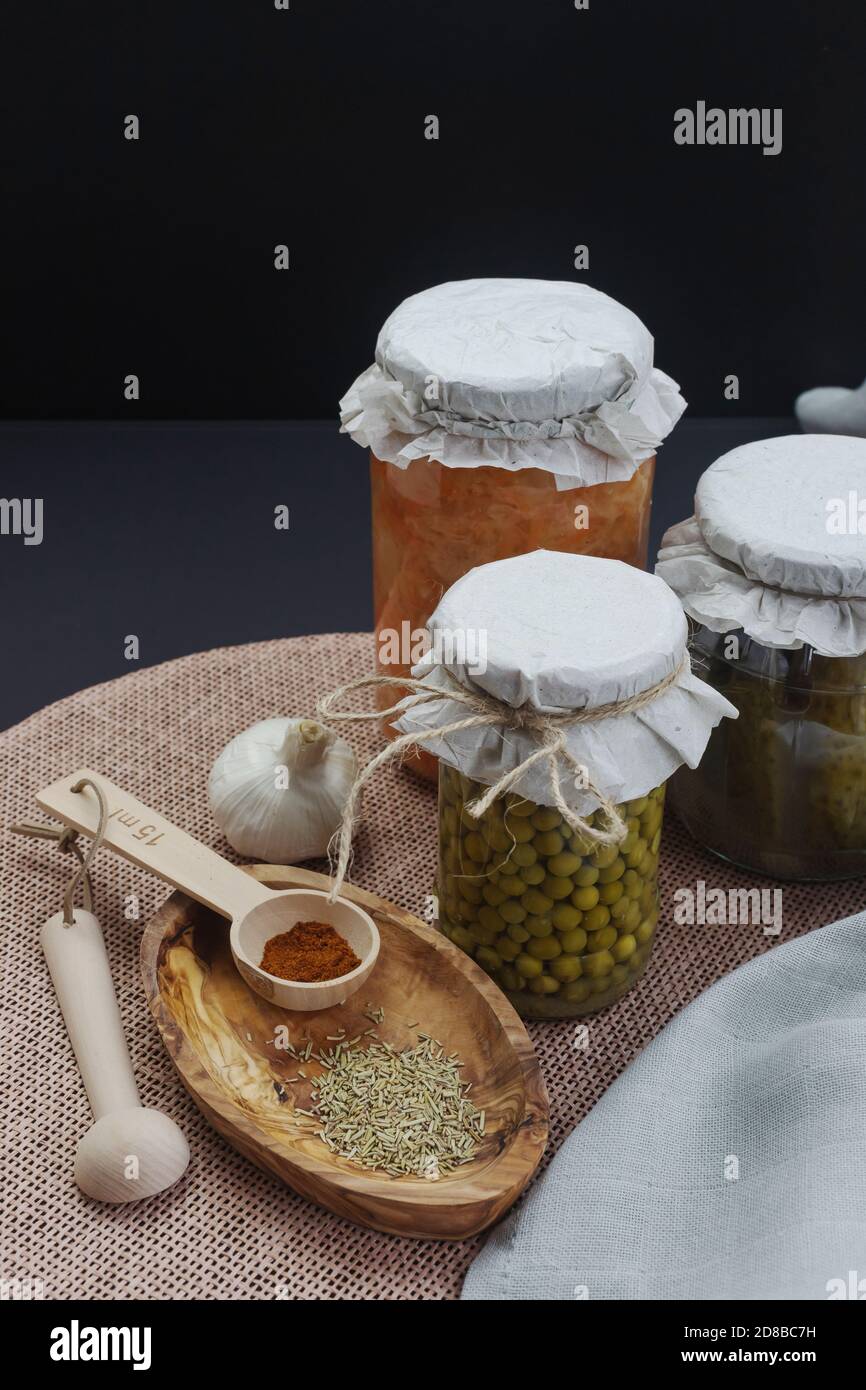 un pot de chou fermenté, de petits pois, de concombres marinés aux épices sur fond sombre Banque D'Images