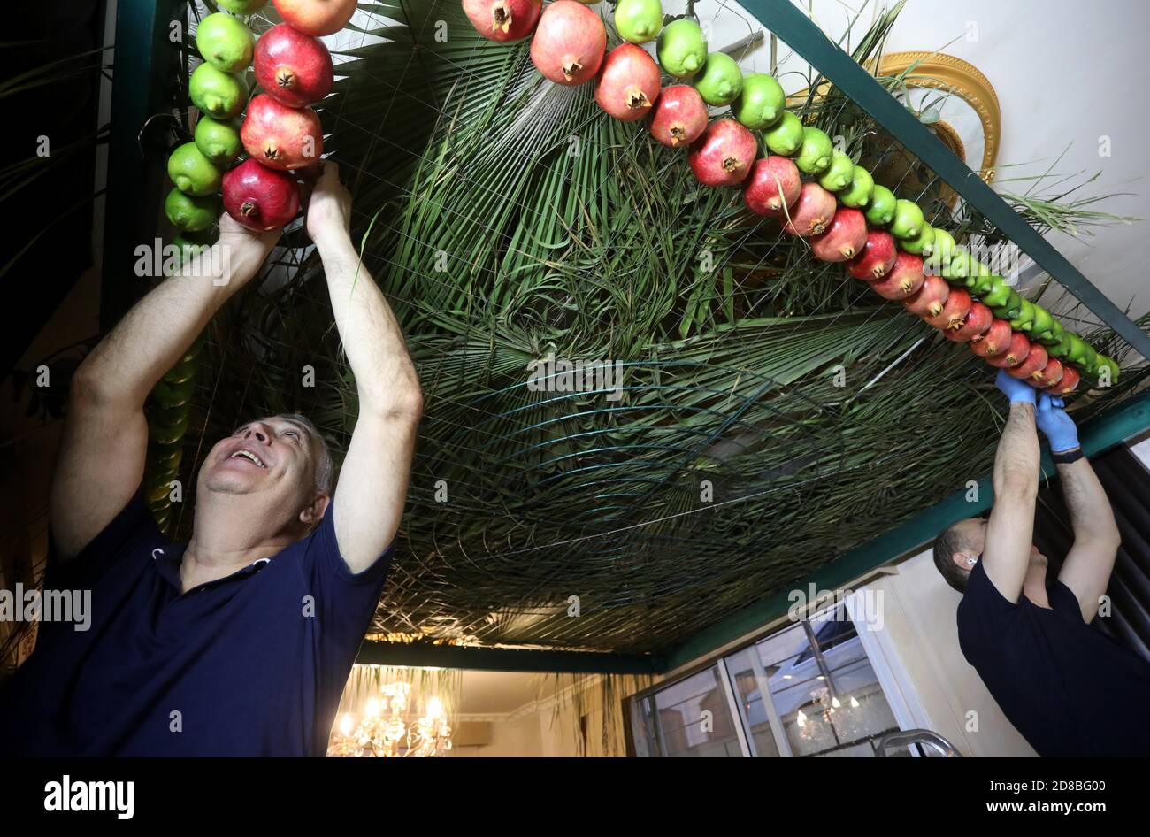 Naplouse, Mont Gerizim près de la ville de Naplouse, en Cisjordanie. 28 octobre 2020. Les Samaritains pendent des fruits au plafond de leur maison en préparation à la célébration de Soukkot, Fête des Tabernacles, au Mont Gerizim près de la ville de Naplouse, en Cisjordanie, le 28 octobre 2020. Les Samaritains ont décoré leurs plafonds de fruits sous une forme géométrique pour commémorer l'exode des Juifs d'Égypte. Credit: Ayman Nobani/Xinhua/Alamy Live News Banque D'Images