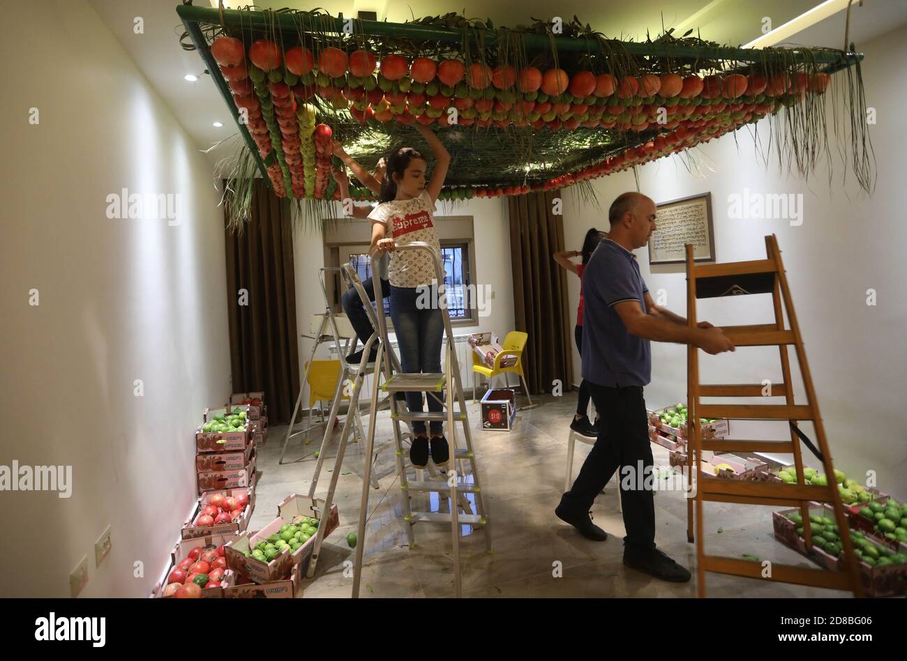Naplouse, Mont Gerizim près de la ville de Naplouse, en Cisjordanie. 28 octobre 2020. Les Samaritains pendent des fruits au plafond de leur maison en préparation à la célébration de Soukkot, Fête des Tabernacles, au Mont Gerizim près de la ville de Naplouse, en Cisjordanie, le 28 octobre 2020. Les Samaritains ont décoré leurs plafonds de fruits sous une forme géométrique pour commémorer l'exode des Juifs d'Égypte. Credit: Ayman Nobani/Xinhua/Alamy Live News Banque D'Images