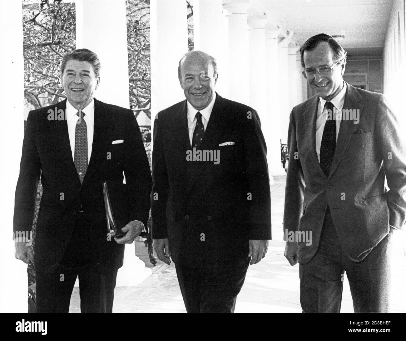 Le président américain Ronald Reagan, à gauche, le secrétaire d’État américain George P. Shultz, au centre, et le vice-président américain George H.W. Bush, à droite, marchez sur la Colonnade depuis le bureau ovale jusqu'à la résidence de la Maison Blanche à Washington, DC, le 9 janvier 1985. Shultz revient dans la capitale après ses entretiens avec le ministre des Affaires étrangères Andrei Gromyko de l'URSS à Genève, Suisse. Crédit: Pool via CNP | usage dans le monde entier Banque D'Images