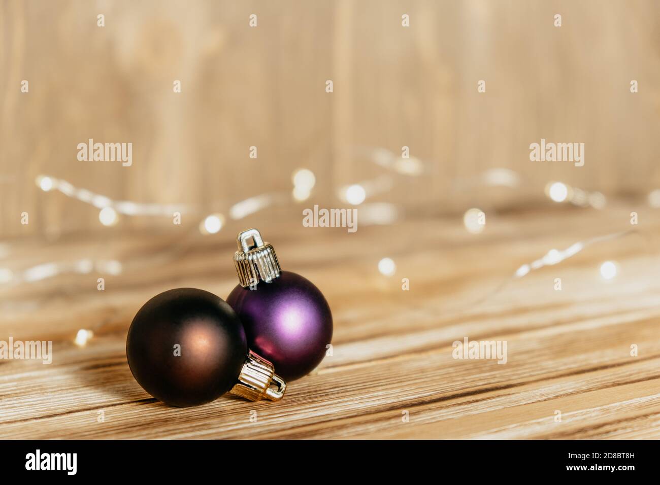 Carte de Noël avec boules de Noël et guirlande sur fond de bois. Lumières de fond et décorations de Noël. Mise au point sélective. Banque D'Images