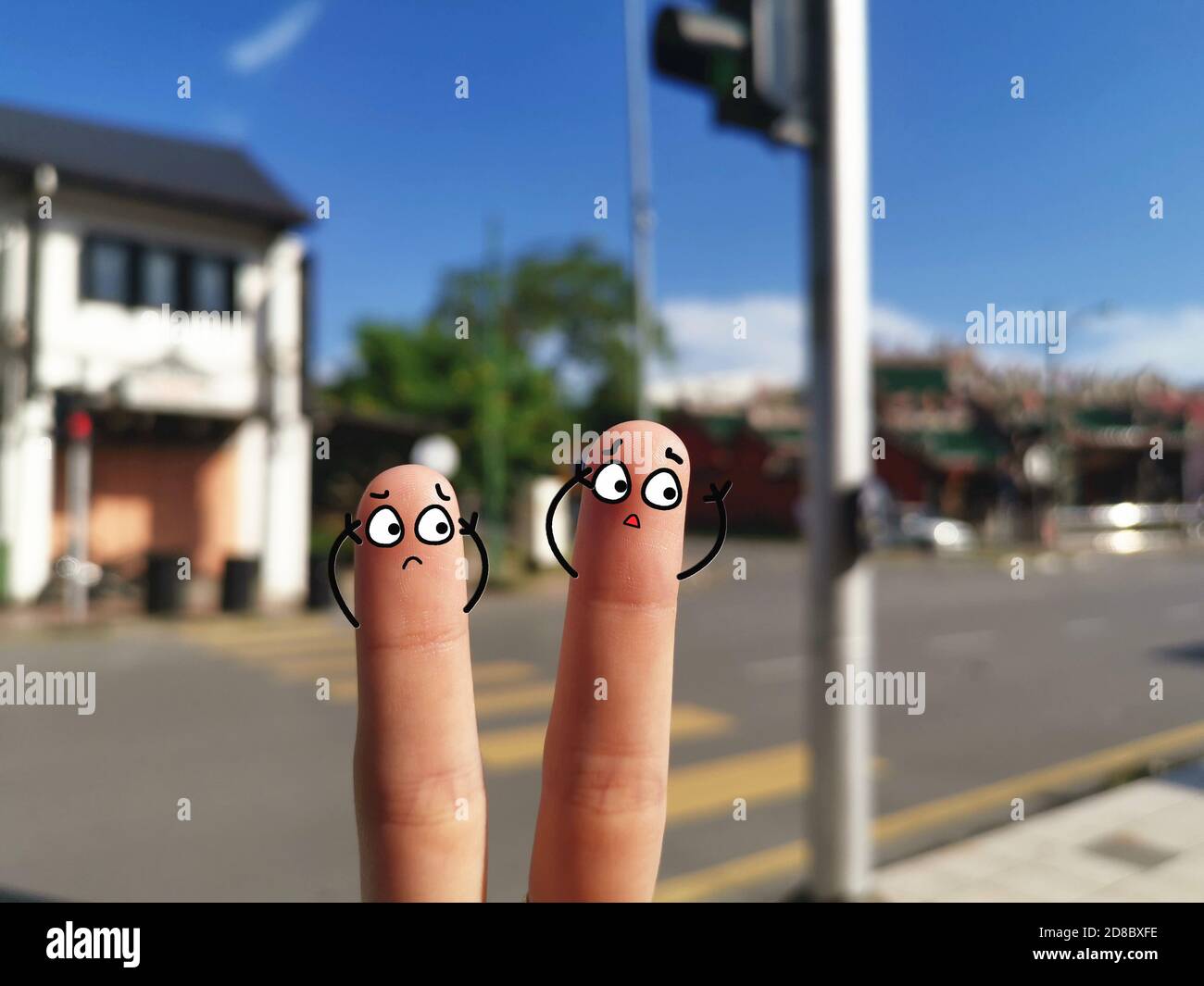 Deux doigts sont décorés pour deux personnes. Ils sont énervés par la pollution sonore continue. Banque D'Images