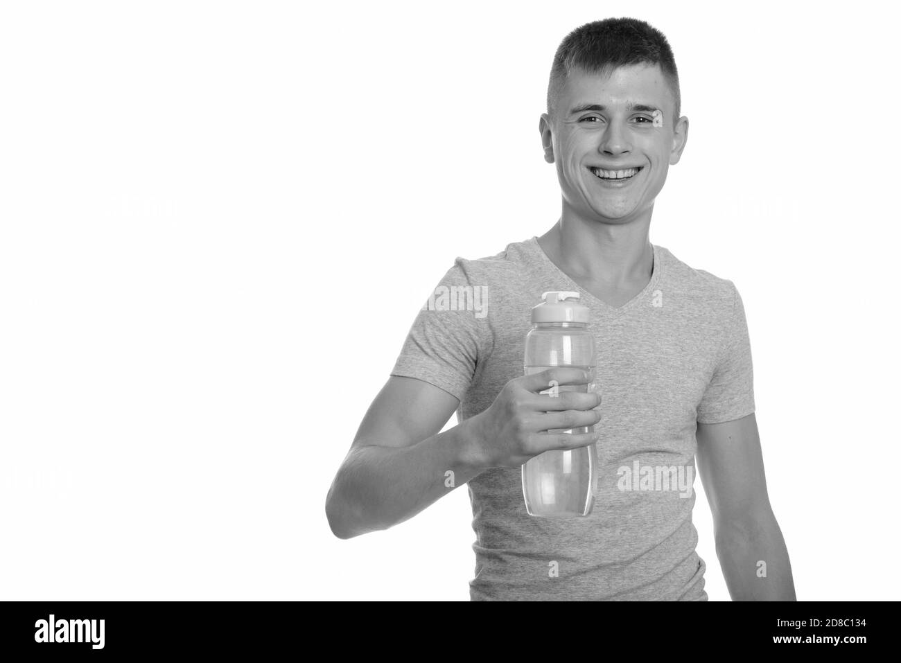 Young happy man smiling and holding water bottle Banque D'Images