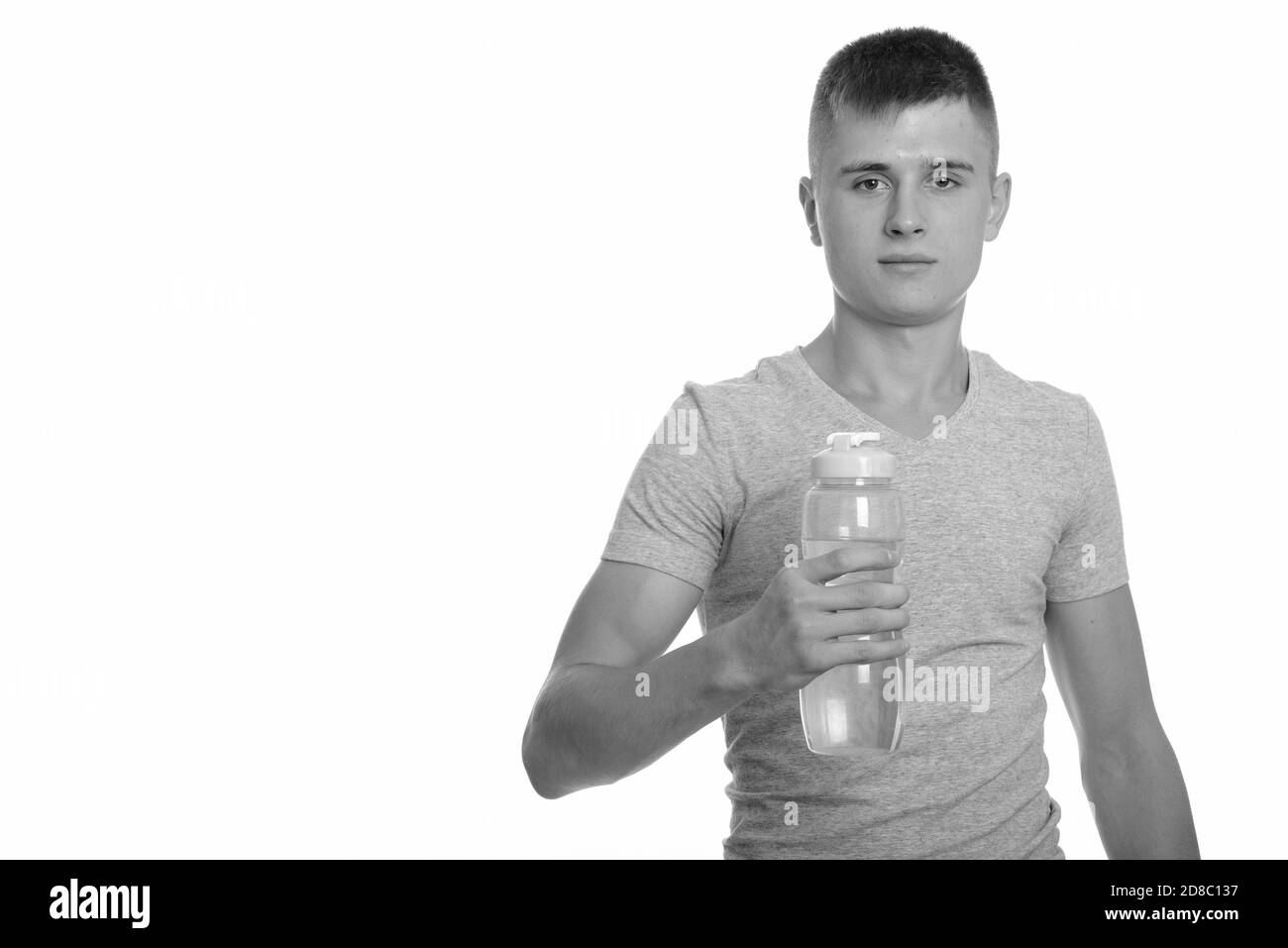 Portrait d'un jeune homme beau tenant une bouteille d'eau Banque D'Images
