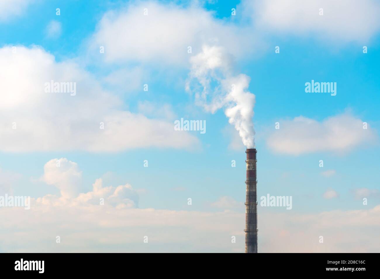 Tuyau unique avec émissions de fumée par temps ensoleillé avec nuages Banque D'Images