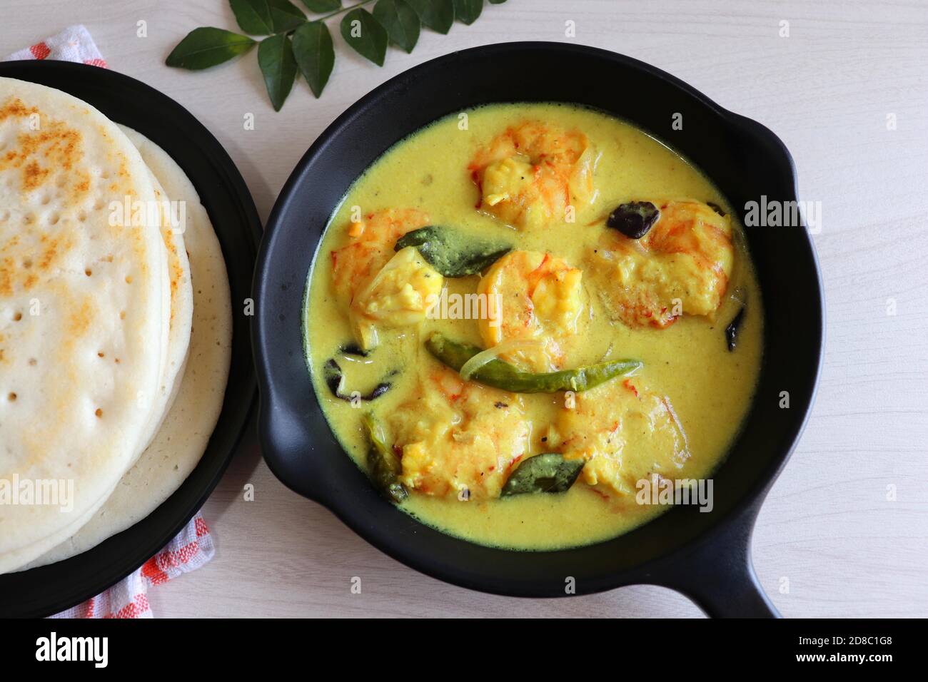 Crevettes jaunes ou curry de crevettes servies avec Amboli ou Soft Dosa. Crevettes cuites dans du lait de coco aux épices douces. Curry thaïlandais jaune de crevettes. Curry de Goan. Banque D'Images