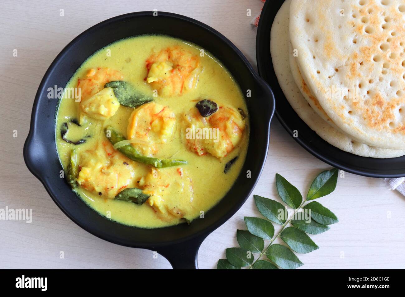 Crevettes jaunes ou curry de crevettes servies avec Amboli ou Soft Dosa. Crevettes cuites dans du lait de coco aux épices douces. Curry thaïlandais jaune de crevettes. Curry de Goan. Banque D'Images