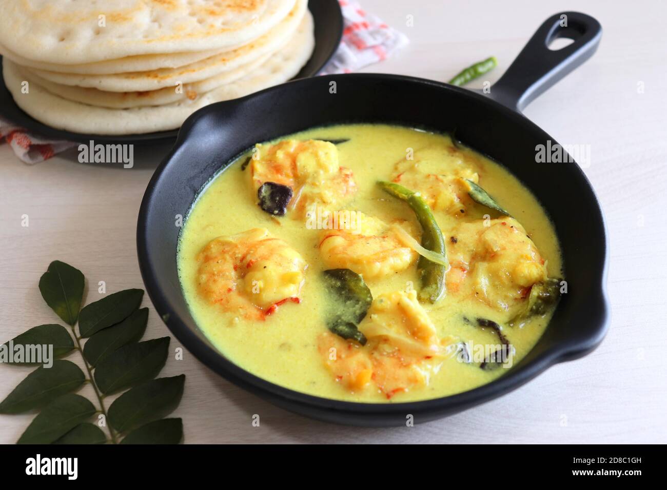 Crevettes jaunes ou curry de crevettes servies avec Amboli ou Soft Dosa. Crevettes cuites dans du lait de coco aux épices douces. Curry thaïlandais jaune de crevettes. Curry de Goan. Banque D'Images
