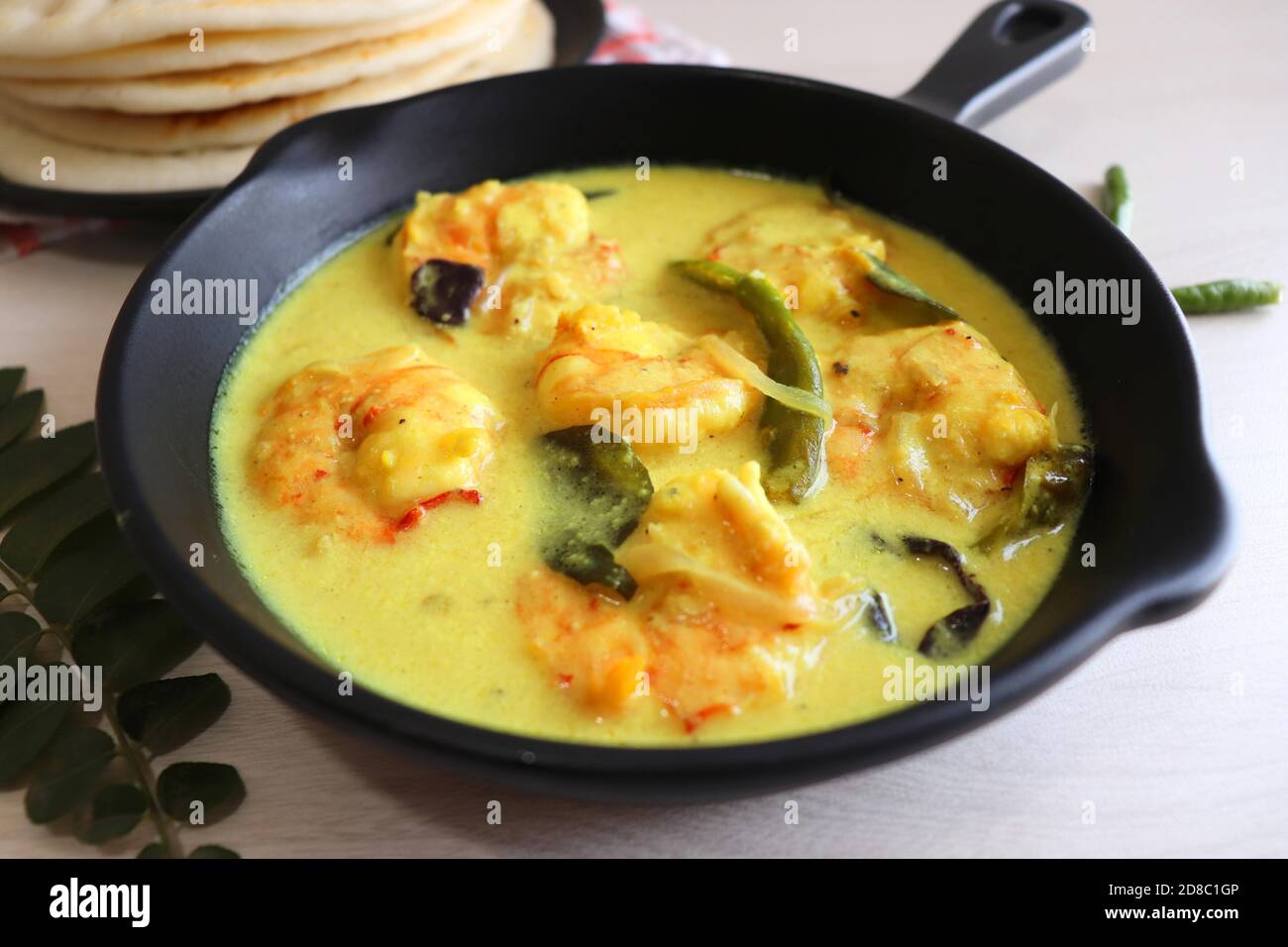 Crevettes jaunes ou curry de crevettes servies avec Amboli ou Soft Dosa. Crevettes cuites dans du lait de coco aux épices douces. Curry thaïlandais jaune de crevettes. Curry de Goan. Banque D'Images