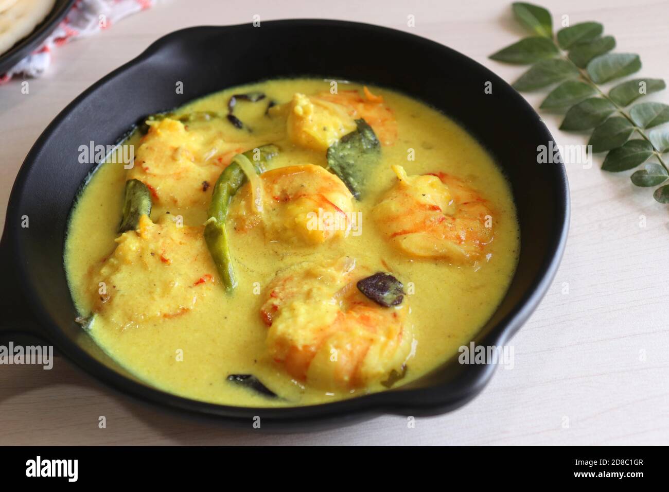 Crevettes jaunes ou curry de crevettes servies avec Amboli ou Soft Dosa. Crevettes cuites dans du lait de coco aux épices douces. Curry thaïlandais jaune de crevettes. Curry de Goan. Banque D'Images