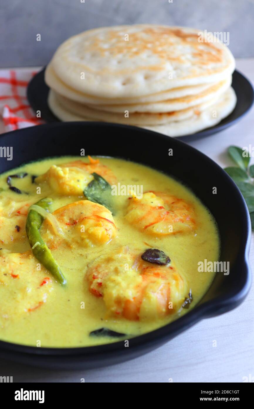 Crevettes jaunes ou curry de crevettes servies avec Amboli ou Soft Dosa. Crevettes cuites dans du lait de coco aux épices douces. Curry thaïlandais jaune de crevettes. Curry de Goan. Banque D'Images