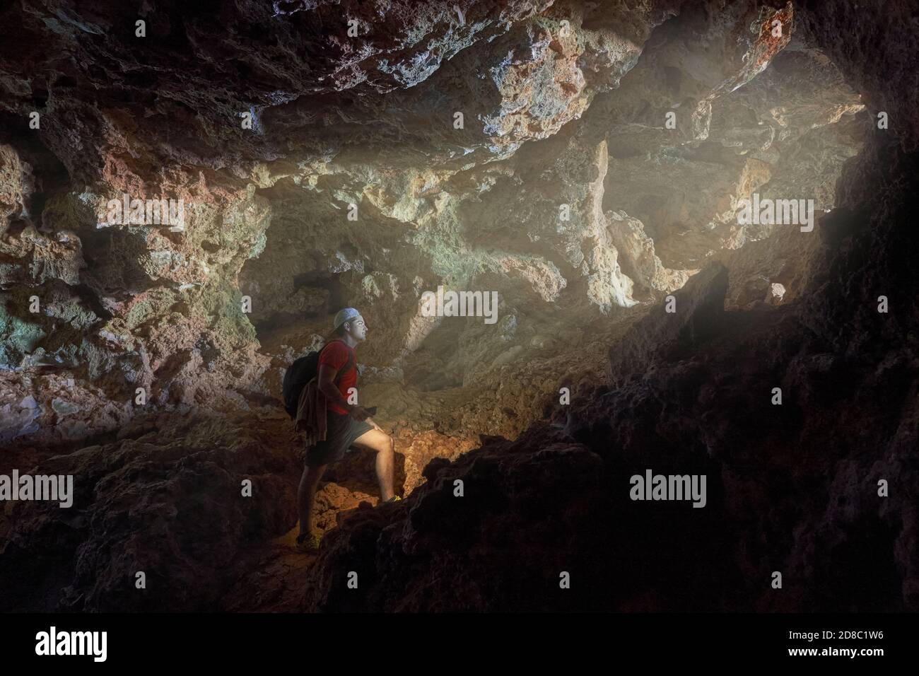 Randonneur aventureux explorant la grotte rocheuse de la montagne Banque D'Images