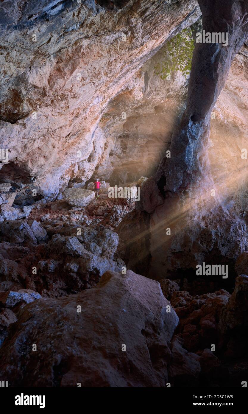 Randonneur aventureux explorant les magnifiques grottes rocheuses de la montagne Banque D'Images