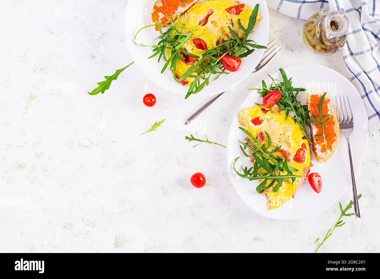 Omelette aux tomates, fromage, jambon et sandwich au cavier rouge sur l'assiette. Frittata - omelette italienne. Vue de dessus, au-dessus de la tête, espace de copie Banque D'Images