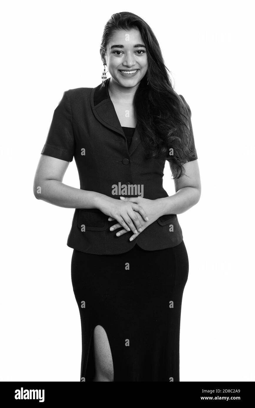 Studio shot of young happy Indian businesswoman smiling while standing Banque D'Images