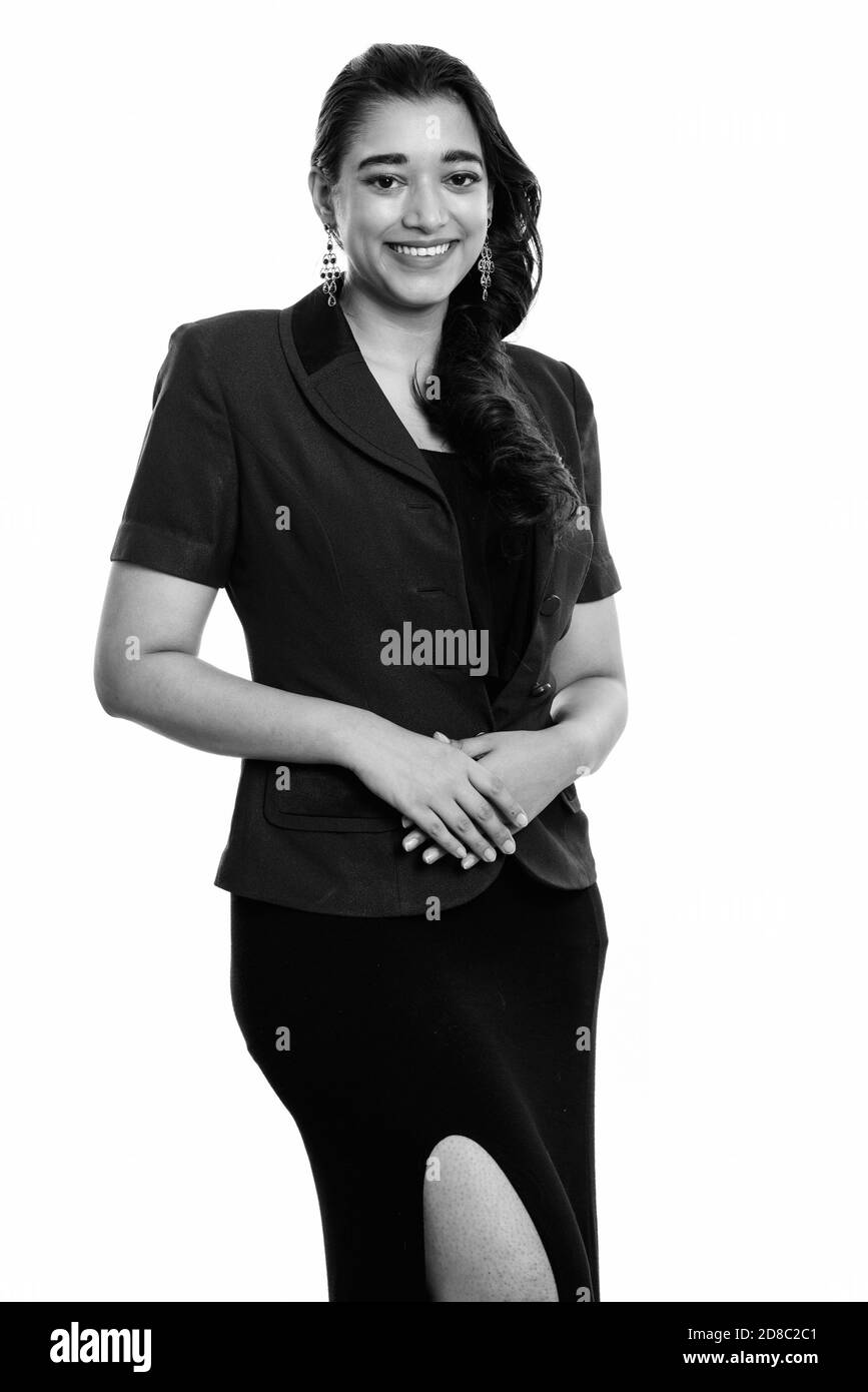 Studio shot of young happy Indian businesswoman smiling while standing Banque D'Images