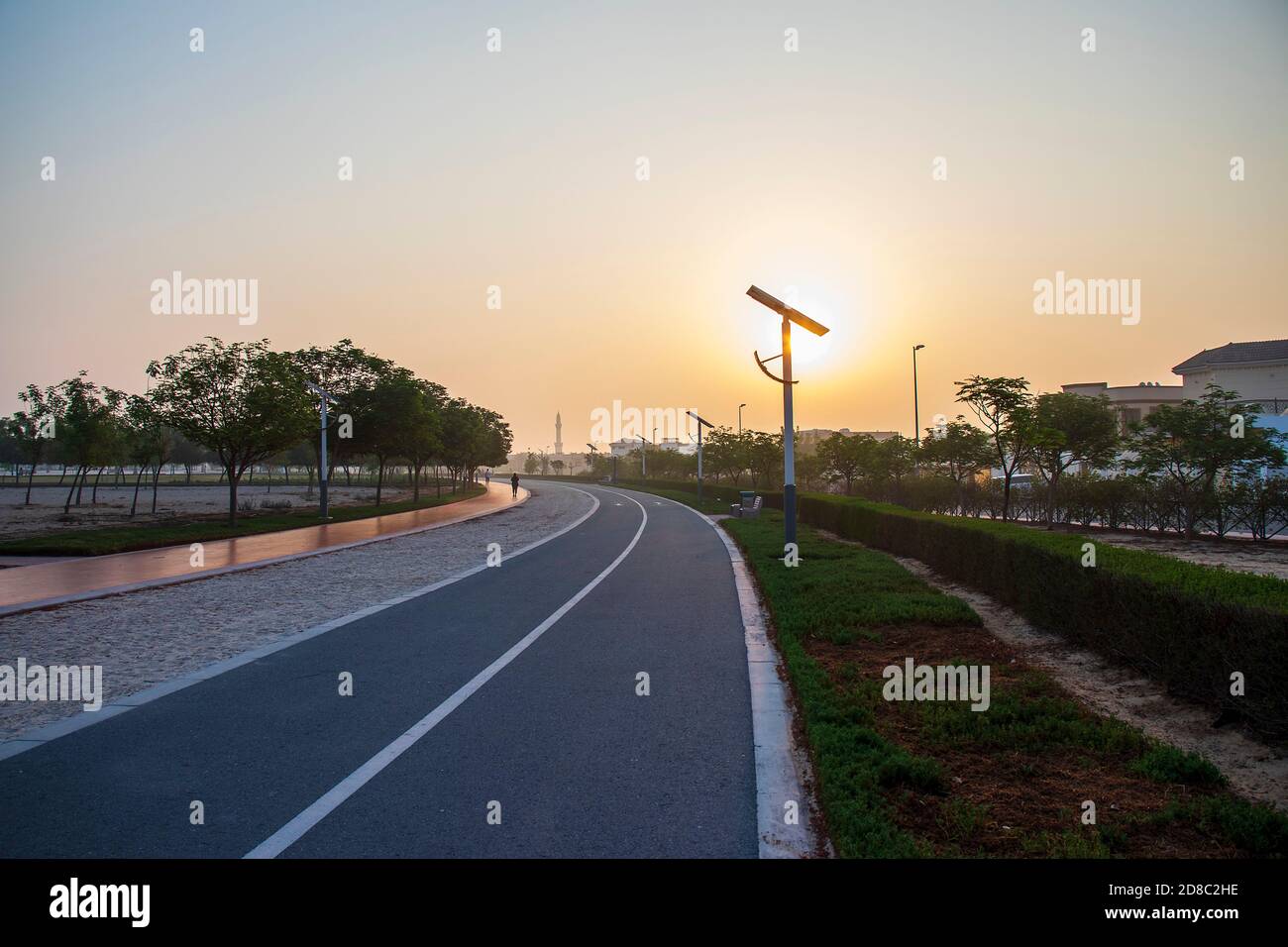 Pistes de jogging et de vélo dans le parc Al Warqa, Dubaï, Émirats arabes Unis tôt le matin. Le poteau de lampe alimenté par des panneaux solaires peut être vu dans l'image aussi bien que Banque D'Images