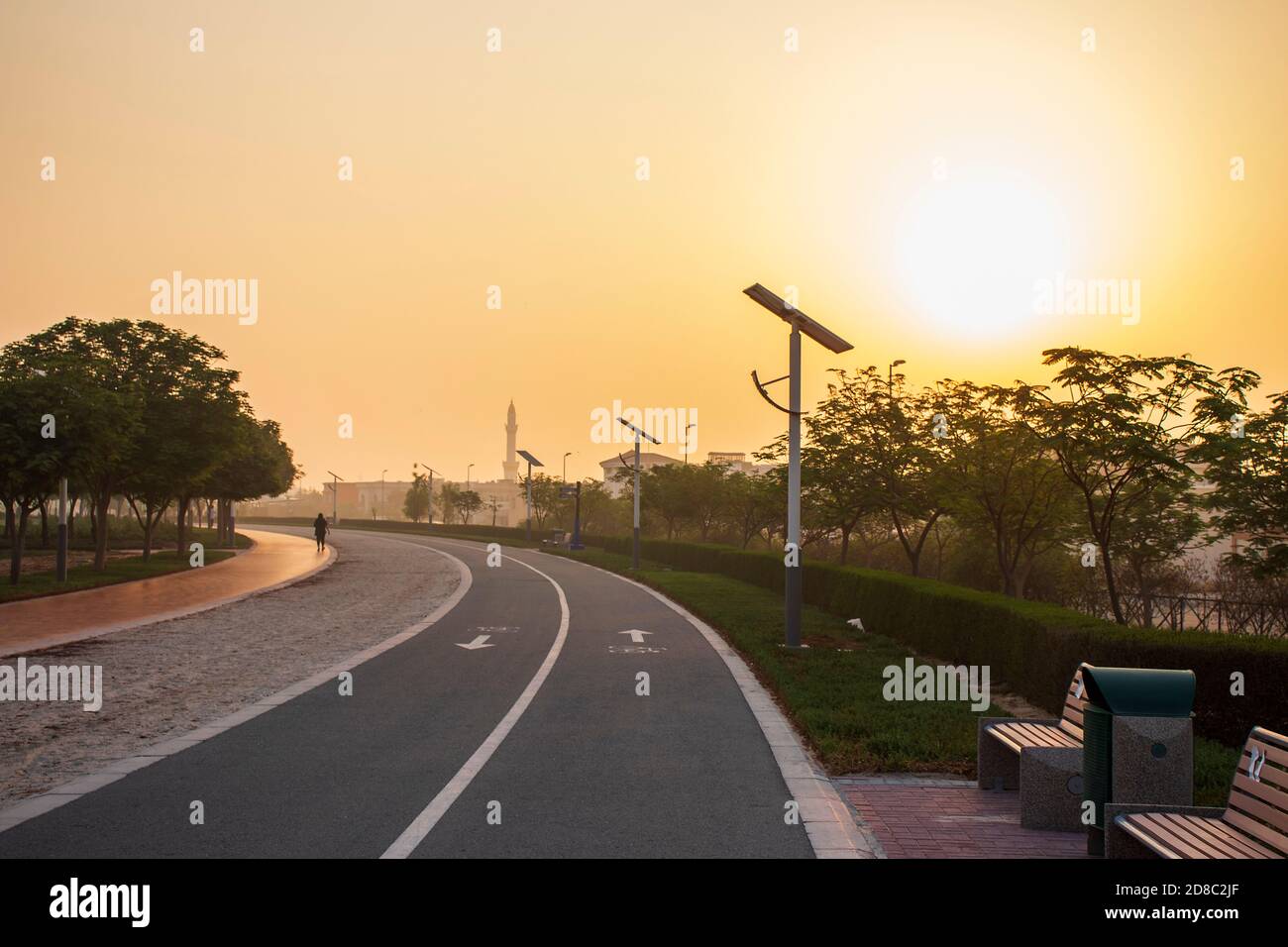 Pistes de jogging et de vélo dans le parc Al Warqa, Dubaï, Émirats arabes Unis tôt le matin. Le poteau de lampe alimenté par des panneaux solaires peut être vu dans l'image aussi bien que Banque D'Images