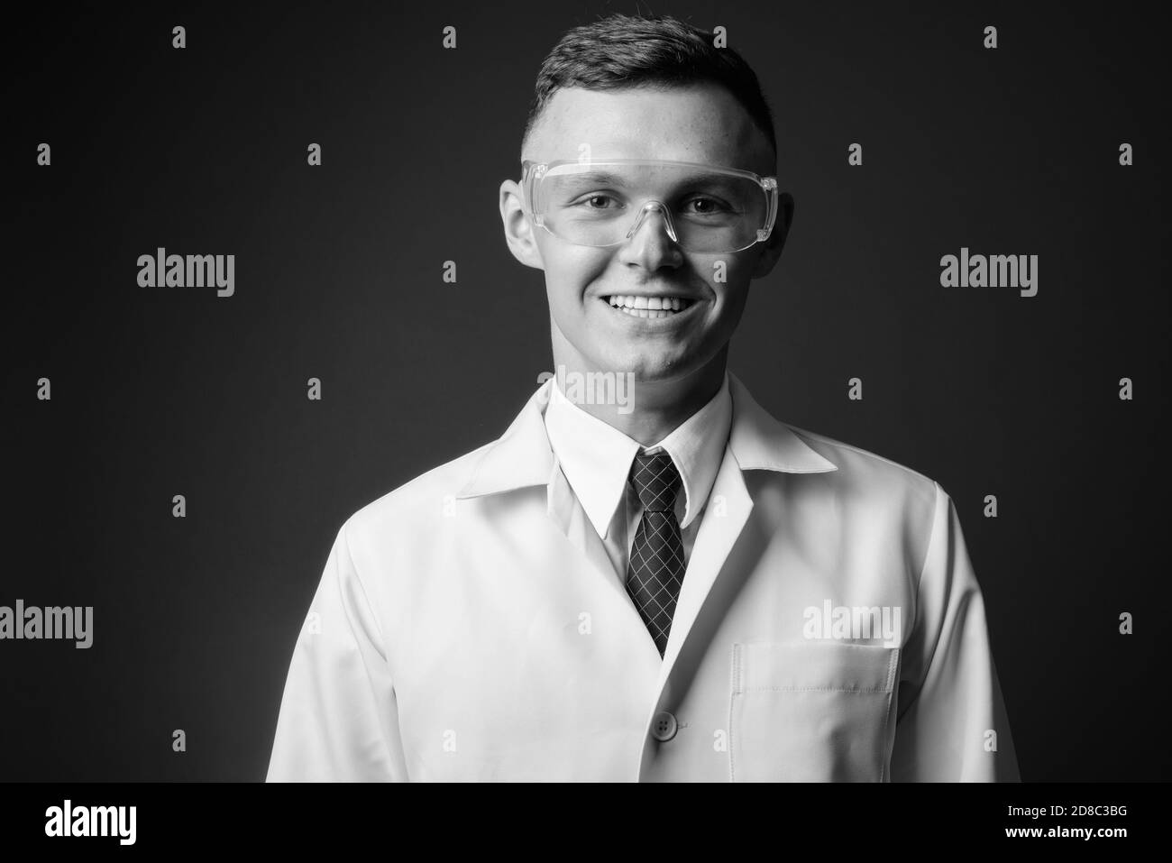 Jeune homme médecin portant des lunettes de protection sur fond gris Banque D'Images
