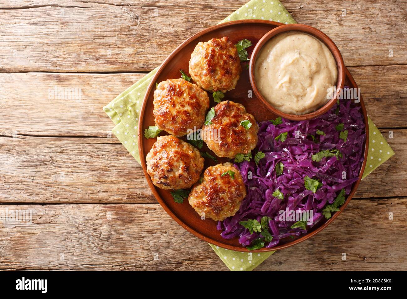 Frikadeller ou boulettes de viande danoises sont des boulettes de viande salées servies avec une sauce crémeuse riche et ragoût de chou rouge dans l'assiette sur la table. Horizontal Banque D'Images