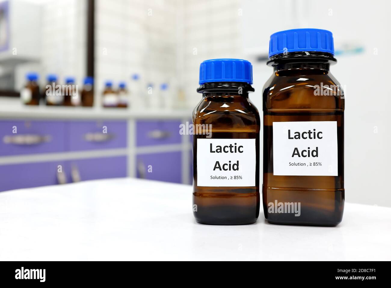 Concentration sélective de la solution liquide d'acide lactique dans un flacon en verre brun foncé dans un laboratoire de chimie blanche. Peau chimique pour les soins de la peau. Banque D'Images