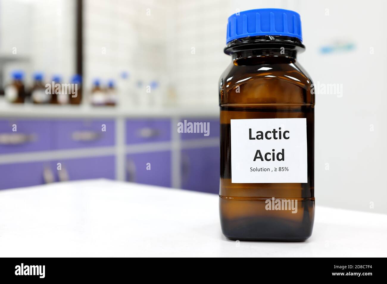 Concentration sélective de la solution liquide d'acide lactique dans un flacon en verre brun foncé dans un laboratoire de chimie blanche. Peau chimique pour les soins de la peau. Banque D'Images