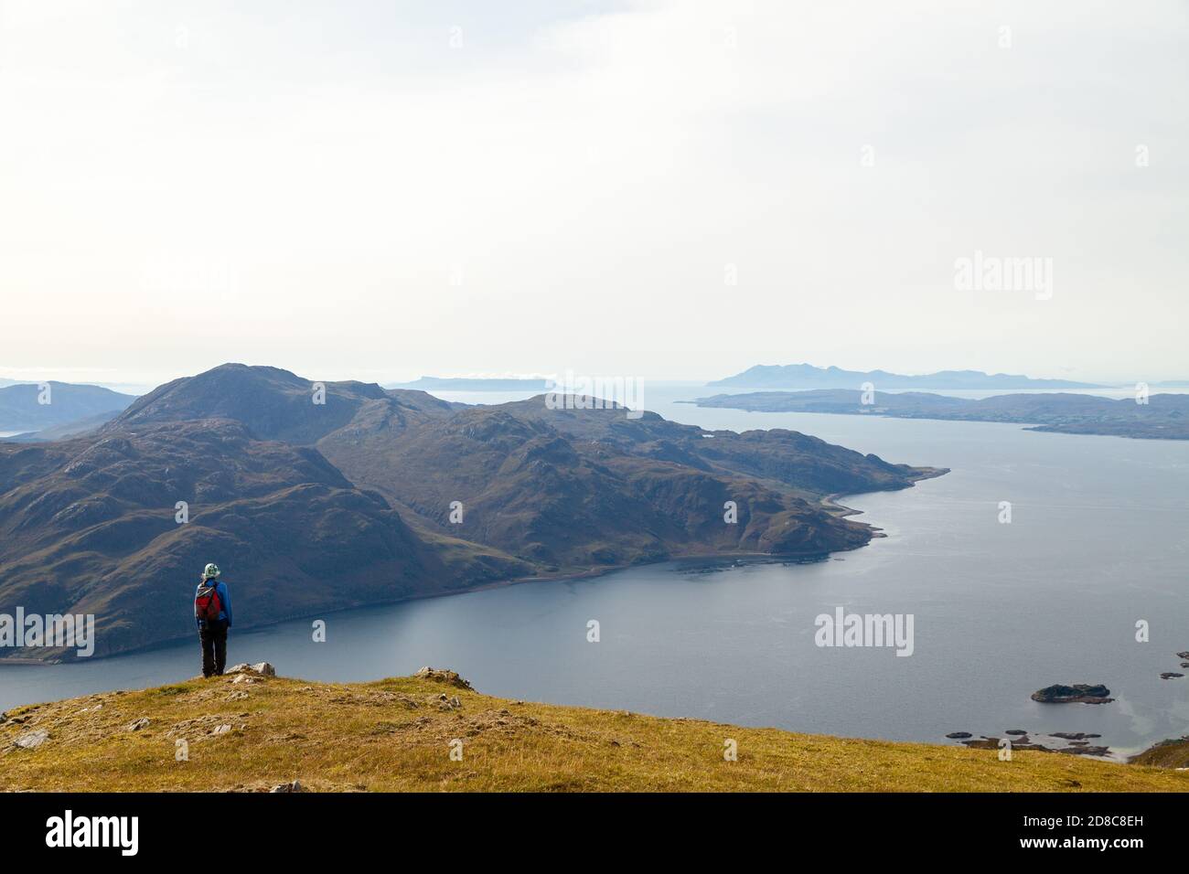 Un marcheur s'arrête pour admirer la vue sur le Loch Hourn Et à la distance de Rum & Eigg de la descente De la Corbett Beinn na h-Eaglaise Banque D'Images