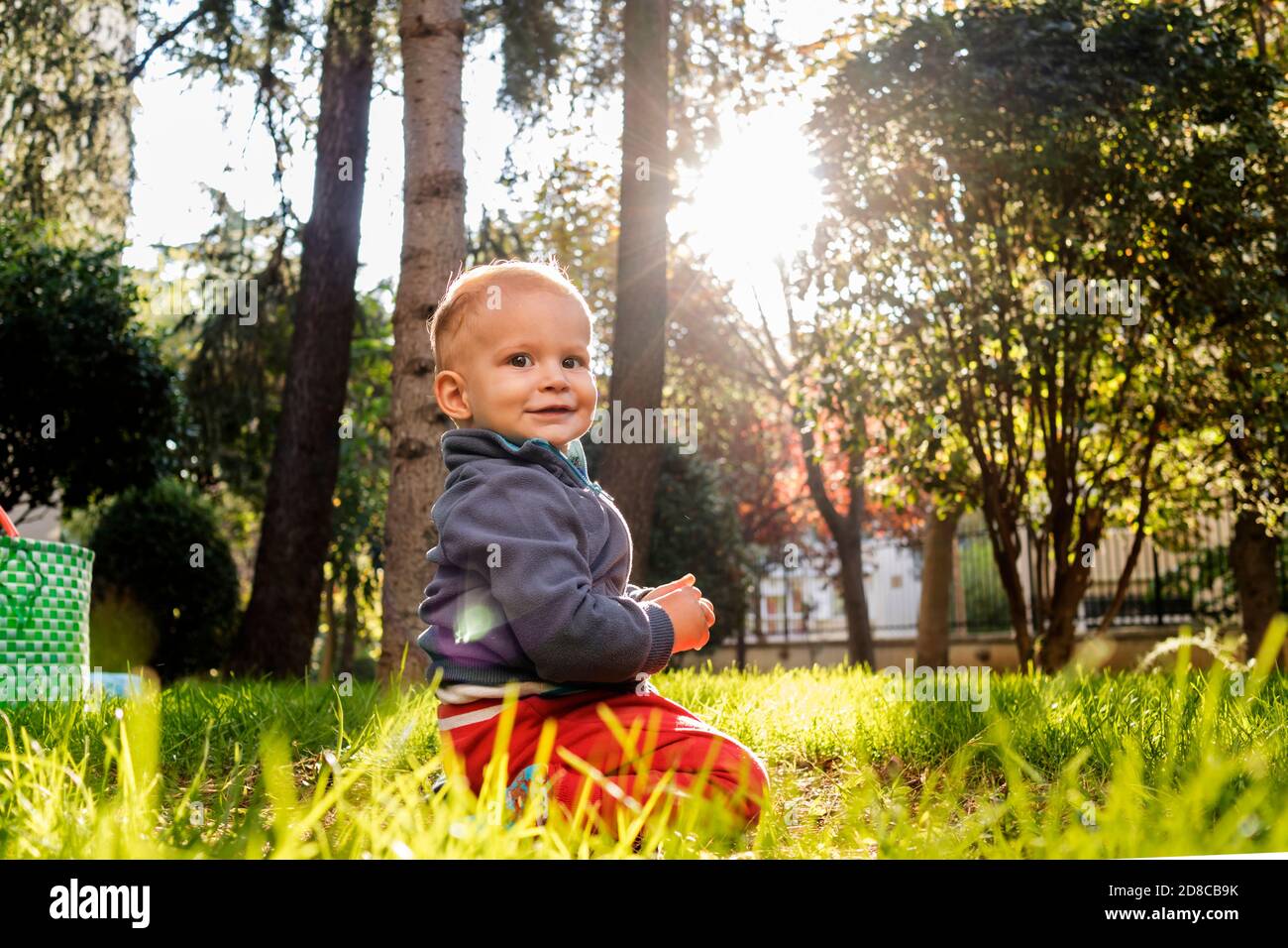 Bébé assis sur l'herbe Banque D'Images