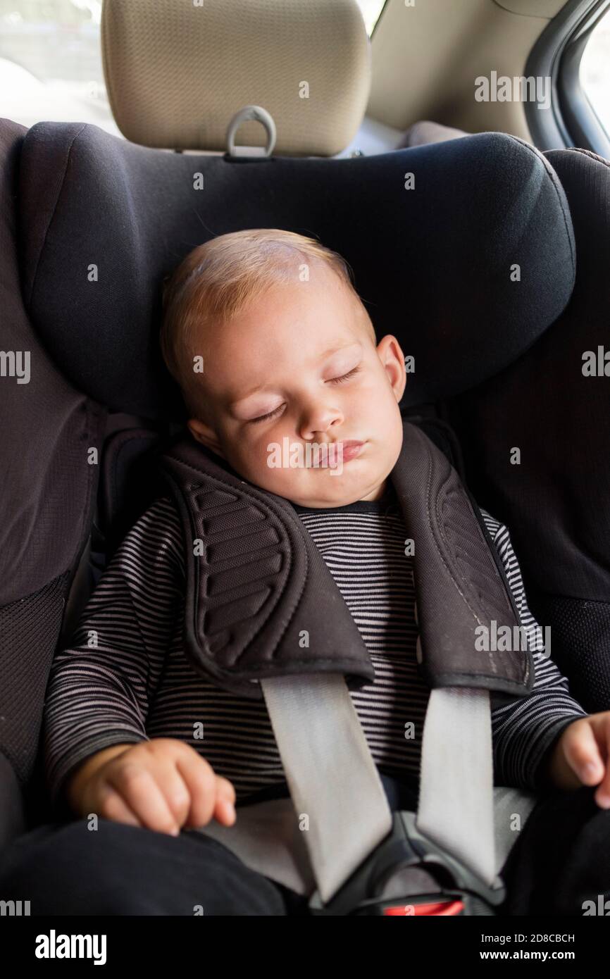 Petit garçon mignon dormant dans un siège d'auto de sécurité Banque D'Images
