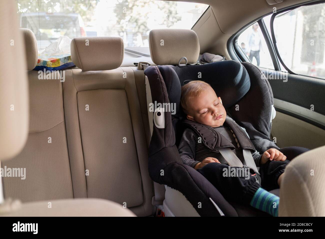 Petit garçon mignon dormant dans un siège d'auto de sécurité Banque D'Images