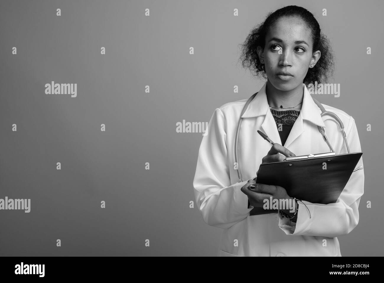 Belle jeune femme africaine médecin contre l'arrière-plan gris Banque D'Images