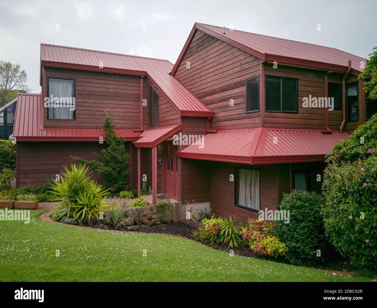 AUCKLAND, NOUVELLE-ZÉLANDE - 11 octobre 2019 : vue sur la maison de banlieue avec toit en métal rouge à Howick Banque D'Images